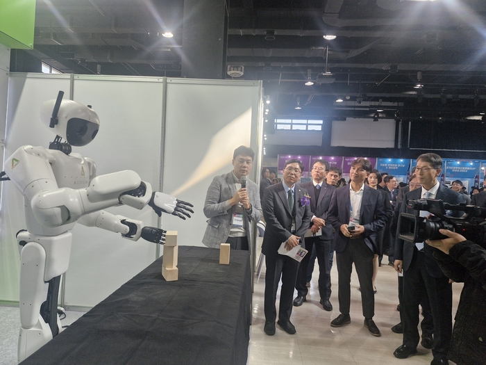 관계자들이 사람과 똑같이 따라하는 로봇 설명을 듣고 있다.(사진=권미현 기자)