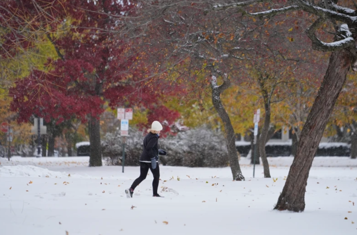 10일(현지시간) 일리노이주 에번스턴에서 한 시민이 가을 단풍 사이로 눈이 쌓인 길을 조깅하고 있다. 사진=AP 연합뉴스
